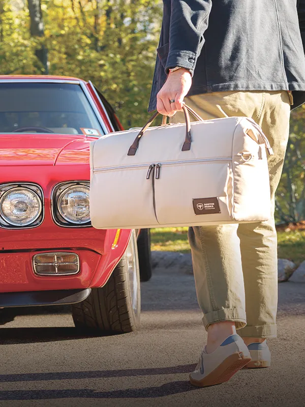 person holding a duffel bag with a custom patch