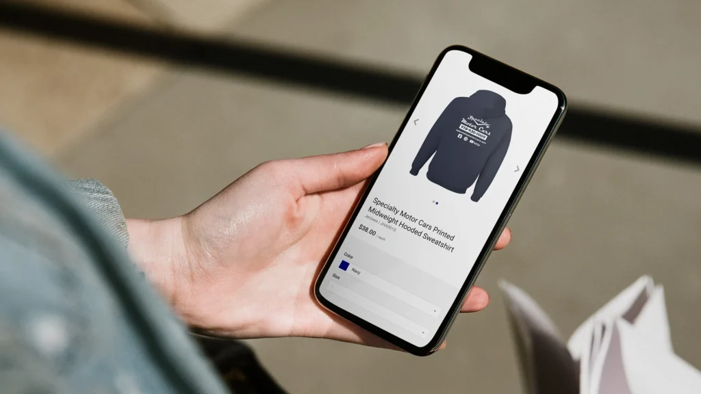 person holding a cellphone with an e-commerce store on the screen